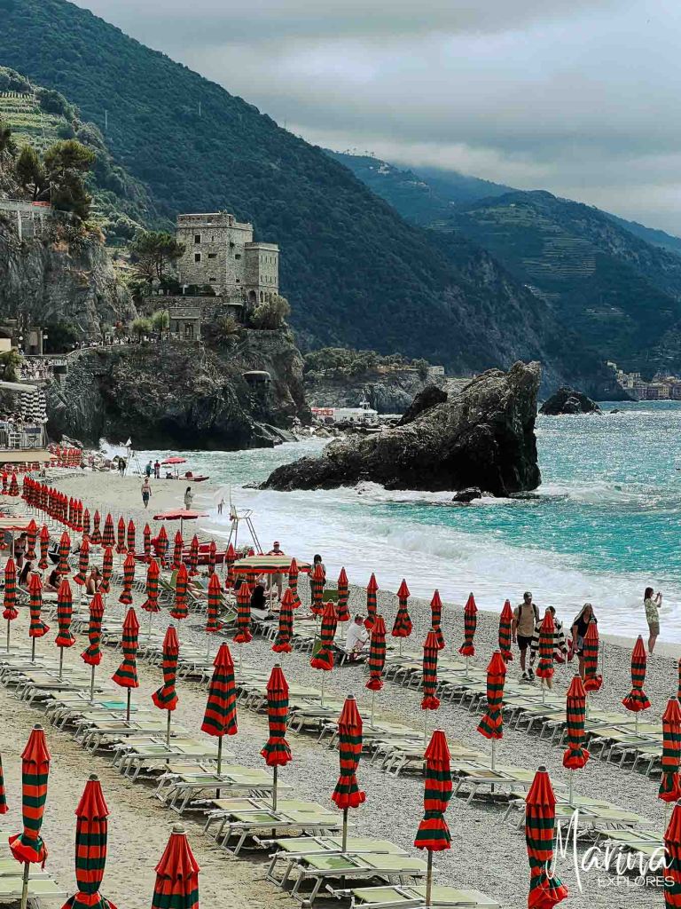 Orange and green umbrellas on beach at Monterosso al Mare Cinque Terre, Italy