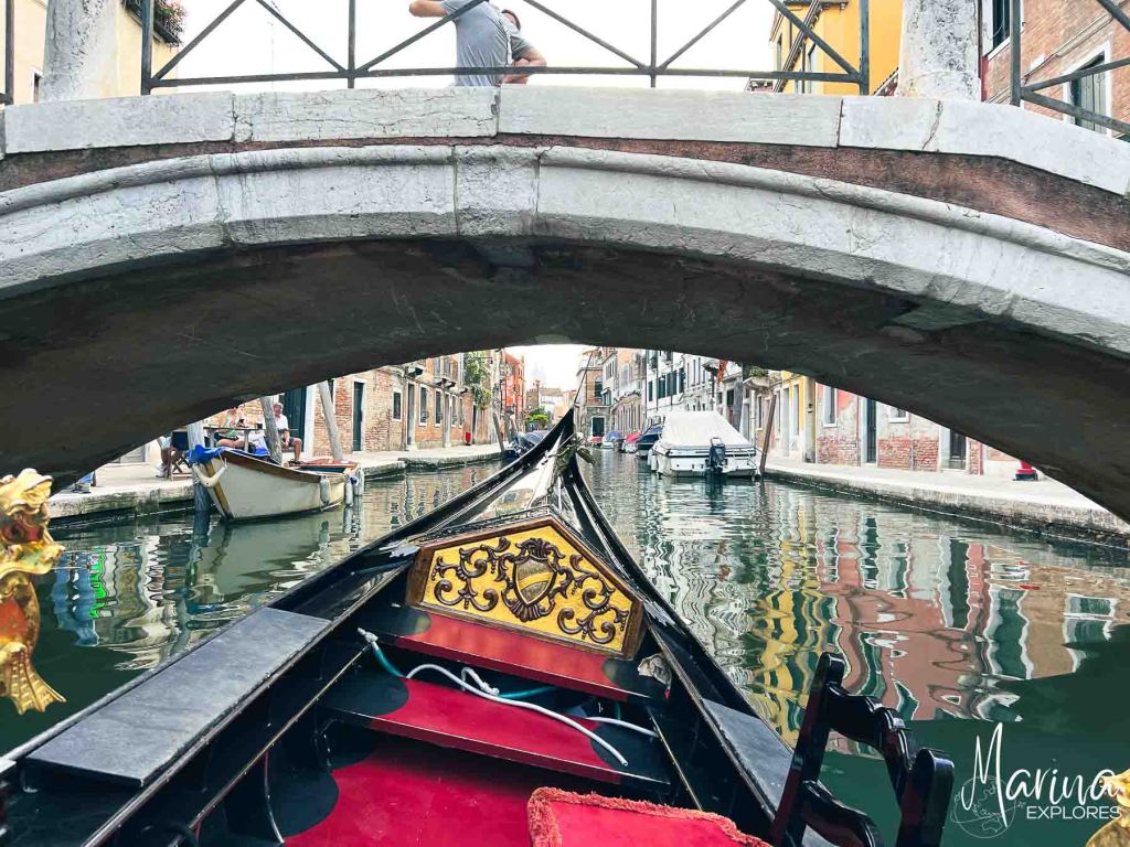 Tipped gondola to go under small footbridge in Venice, Italy