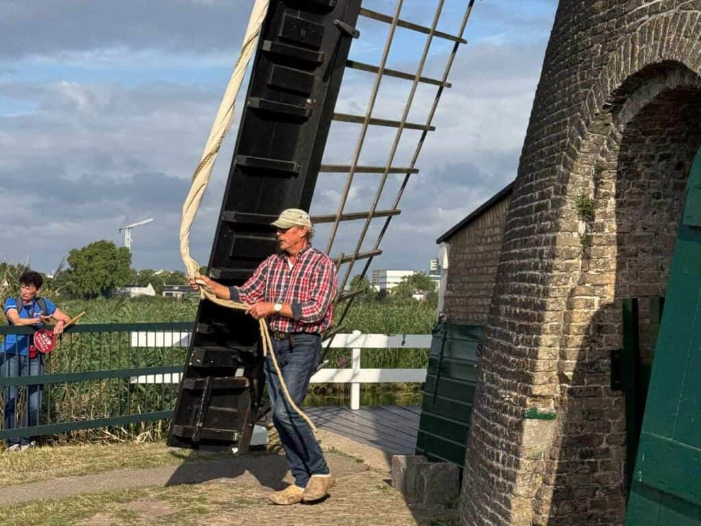 miller opening sail on windmill arm